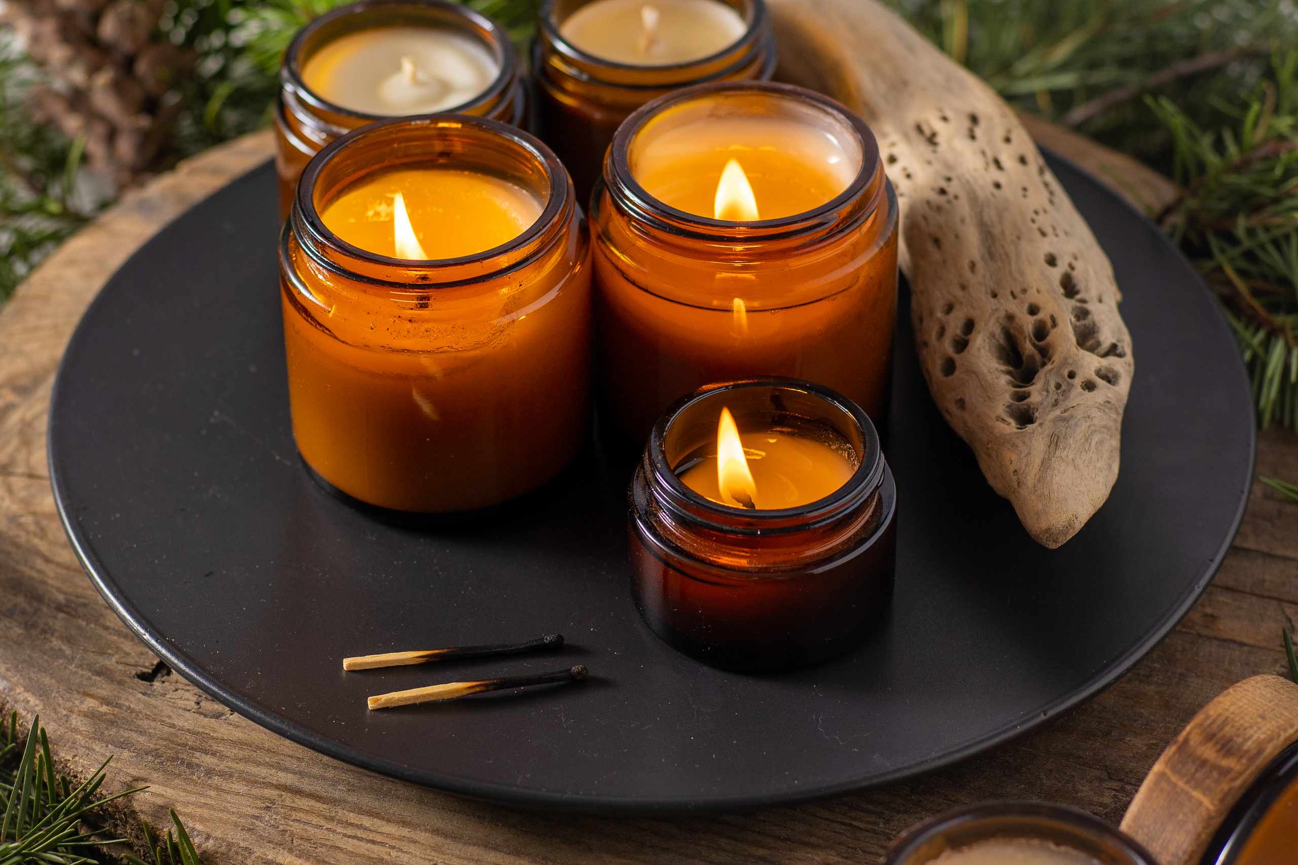 Burning candles with wood on a decorative plate